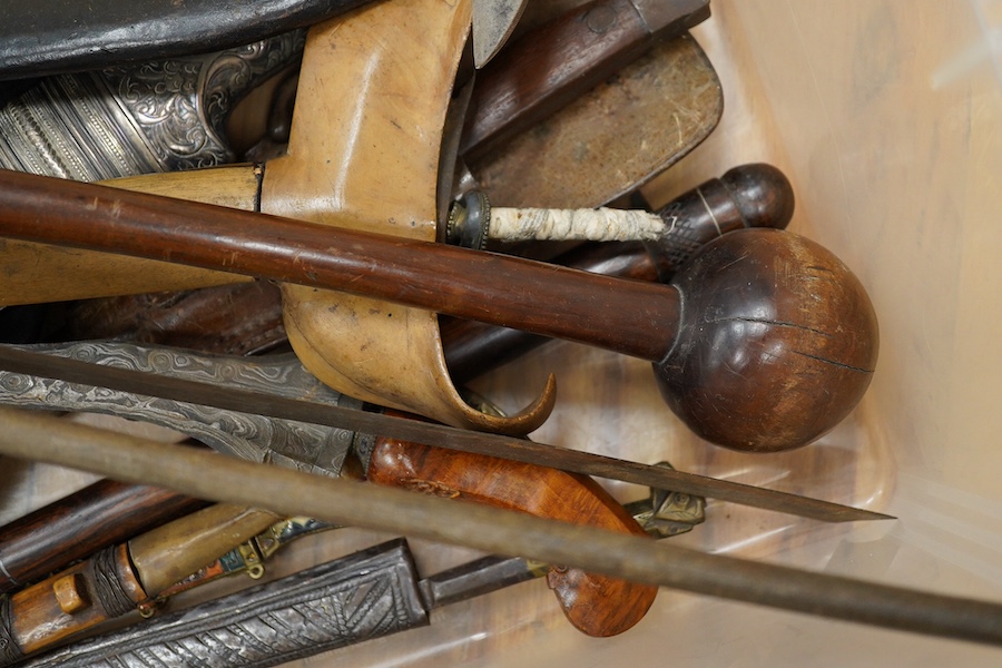 Eighteen assorted world weapons comprising a silver jambya (pommel missing), a knobkerry, a dha, two kris (one with handle missing), a lohar, three kukris, a djambok, a Chinese trousse, a chora, a flyssa, five others and